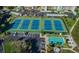 An aerial view of a community's tennis courts, bocce ball court, parking lot, and landscaping at 7862 Sailboat Key S Blvd # 103, South Pasadena, FL 33707