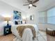 Cozy bedroom features a ceiling fan, comfortable bed, and artistic decor for a serene and inviting space at 7862 Sailboat Key S Blvd # 103, South Pasadena, FL 33707