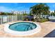 A relaxing community hot tub surrounded by lush tropical landscaping and a privacy fence at 7862 Sailboat Key S Blvd # 103, South Pasadena, FL 33707