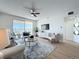 Relaxing living room with a ceiling fan, a water view, and a sliding glass door to a private balcony at 7862 Sailboat Key S Blvd # 103, South Pasadena, FL 33707