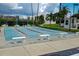 An outdoor shuffleboard court with covered seating, a tropical landscape, and palm trees at 7862 Sailboat Key S Blvd # 103, South Pasadena, FL 33707
