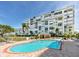 Community swimming pool at a condo with a beautiful patio and views of the building's balconies at 7862 Sailboat Key S Blvd # 103, South Pasadena, FL 33707