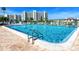 A large community swimming pool with crystal clear water surrounded by lounge chairs and a large condo building in the background at 7862 Sailboat Key S Blvd # 103, South Pasadena, FL 33707