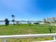 Scenic water view from the property, showcasing lush green spaces and palm trees against a clear blue sky at 7862 Sailboat Key S Blvd # 103, South Pasadena, FL 33707