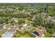 An aerial view of a home with a backyard pool and a solar panel roof in a neighborhood near the river at 8205 Overlook Ne Pl, St Petersburg, FL 33702