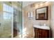 Well-lit bathroom features a vanity, mirror, travertine tile, and a glass-enclosed shower at 8205 Overlook Ne Pl, St Petersburg, FL 33702