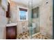 Bathroom with decorative tiling, glass shower, and wood vanity at 8205 Overlook Ne Pl, St Petersburg, FL 33702