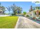 Exterior shot showcasing a spacious driveway, lush green lawn, and the side of a charming home with a detached garage at 8205 Overlook Ne Pl, St Petersburg, FL 33702