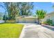 This shot shows a two-car garage with an extra wide driveway surrounded by a well-manicured lawn and a clear blue sky at 8205 Overlook Ne Pl, St Petersburg, FL 33702