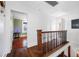 Hallway with wood floors and dark railing leading to the bedrooms at 8205 Overlook Ne Pl, St Petersburg, FL 33702