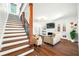 Living room with staircase, hardwood floors, and a fireplace, bathed in natural light at 8205 Overlook Ne Pl, St Petersburg, FL 33702