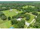 Expansive aerial view of the property featuring mature trees, a lush lawn, outbuildings, and a swimming pool at 9017 S County Line Rd, Lithia, FL 33547
