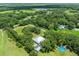 Expansive aerial view of a home with in-ground pool surrounded by lush greenery and mature trees at 9017 S County Line Rd, Lithia, FL 33547