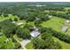 The aerial shot showcases the home and outbuildings among expansive lawns and surrounding trees at 9017 S County Line Rd, Lithia, FL 33547