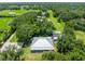 This aerial view highlights the home, the metal roof, and the mature trees on the property at 9017 S County Line Rd, Lithia, FL 33547