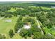 Expansive aerial view of a home surrounded by lush greenery and mature trees on a large property at 9017 S County Line Rd, Lithia, FL 33547