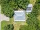 Aerial view displays a gray metal roof with trees surrounding the home and outbuildings at 9017 S County Line Rd, Lithia, FL 33547
