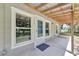 Covered back porch with windows, showing the house's design and offering a view of the property at 9017 S County Line Rd, Lithia, FL 33547