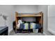 Bright bedroom featuring a wooden bunk bed with colorful striped bedding and gray carpet at 9017 S County Line Rd, Lithia, FL 33547