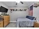 Bedroom with wood dresser, grey walls, ceiling fan, and accents including hats and an American flag at 9017 S County Line Rd, Lithia, FL 33547