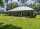 This charming single-story home has a porch, a metal roof, and a spacious front yard at 9017 S County Line Rd, Lithia, FL 33547