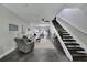 Open-concept living room with modern staircase, neutral decor, and cozy seating area leading to dining space at 9017 S County Line Rd, Lithia, FL 33547
