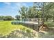 Wooden deck with latticework surrounds the above-ground pool, blending functionality with backyard appeal at 9017 S County Line Rd, Lithia, FL 33547