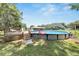 This above ground pool features a deck with lounge seating, a flamingo float and lush landscaping at 9017 S County Line Rd, Lithia, FL 33547