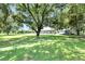 Home nestled on a large, grassy property with mature trees offering shade and a sense of seclusion at 9017 S County Line Rd, Lithia, FL 33547
