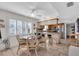 Bright dining area with a glass-top table, rattan chairs, and a ceiling fan, adjacent to the kitchen at 10301 Gulf Blvd # 302, Treasure Island, FL 33706