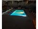 Nighttime shot of the illuminated pool with lounge chairs and tables at 10301 Gulf Blvd # 302, Treasure Island, FL 33706