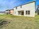 View of the backyard showcasing the lawn with the home's patio and windows at 10818 Breaking Rocks Dr, Tampa, FL 33647