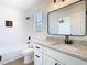 Bathroom boasts granite counters, sleek fixtures, tub with modern tile, and natural light at 10818 Breaking Rocks Dr, Tampa, FL 33647