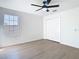 Bedroom with window, closet, ceiling fan, and wood-look flooring at 10818 Breaking Rocks Dr, Tampa, FL 33647