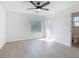 Bright bedroom with ceiling fan, window, and wood-look flooring at 10818 Breaking Rocks Dr, Tampa, FL 33647