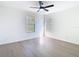 Bright bedroom with two windows, a ceiling fan, and wood-look flooring at 10818 Breaking Rocks Dr, Tampa, FL 33647