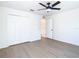 Bedroom with ceiling fan, wood-look flooring, and closet with folding doors at 10818 Breaking Rocks Dr, Tampa, FL 33647