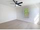 Bedroom with window, ceiling fan, and wood-look flooring at 10818 Breaking Rocks Dr, Tampa, FL 33647