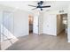 Bedroom with ensuite bathroom boasts a ceiling fan and wood-look floors at 10818 Breaking Rocks Dr, Tampa, FL 33647