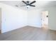 Bright, open bedroom with ceiling fan and wood-look floors leads to an ensuite bathroom at 10818 Breaking Rocks Dr, Tampa, FL 33647