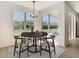 Dining area with a wooden table set on a decorative rug under a stylish light fixture with beautiful outdoor views at 10818 Breaking Rocks Dr, Tampa, FL 33647