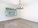 Spacious dining room featuring hardwood floors, a modern chandelier and large windows at 10818 Breaking Rocks Dr, Tampa, FL 33647