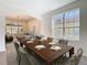 Open dining room with large windows and hardwood floors and a living room beyond at 10818 Breaking Rocks Dr, Tampa, FL 33647