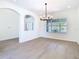 Bright dining room with hardwood floors, connecting archways and a large window at 10818 Breaking Rocks Dr, Tampa, FL 33647
