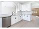 Modern kitchen featuring white cabinetry, stainless steel dishwasher, and granite countertops at 10818 Breaking Rocks Dr, Tampa, FL 33647
