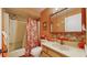 Cozy bathroom with orange walls, patterned shower curtain, and mosaic tile backsplash at 11135 Carriage Hill Dr # 5, Port Richey, FL 34668