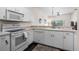 Efficient kitchen features white appliances and cabinets, plus a sleek countertop with breakfast bar at 1120 Radison Ave # 6, Sun City Center, FL 33573