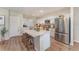 Bright kitchen with white cabinets, stainless steel appliances, and island with quartz countertop at 12970 Pasture Woods Pl, Lithia, FL 33547