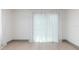 Bright empty bedroom with neutral walls, light wood floors, and sheer curtains over the windows at 1320 Coral S Way, St Petersburg, FL 33705