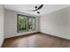 Spacious bedroom with hardwood floors, a modern ceiling fan, and two large windows at 1320 Coral S Way, St Petersburg, FL 33705